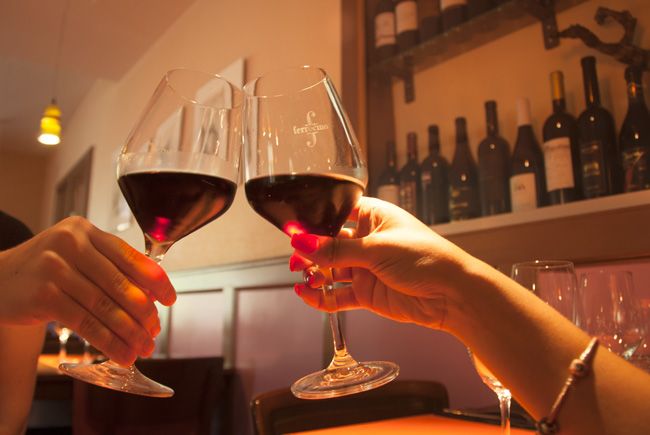 Entreprise - Photographie en vue rapprochée de deux personnes qui font santé avec un verre de vin pour le restaurant de la Clef